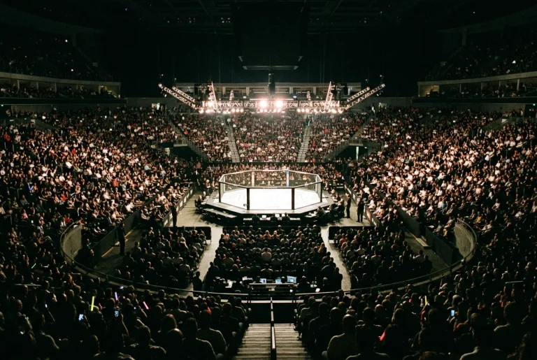 Salle d'arène comble avec une cage de MMA éclairée au centre